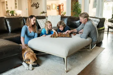 family playing chess in the living room
